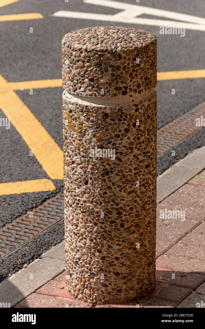una vista ravvicinata di un palo in cemento che viene posizionato per impedire l'ingresso di auto, camion e veicoli pesanti Foto Stock