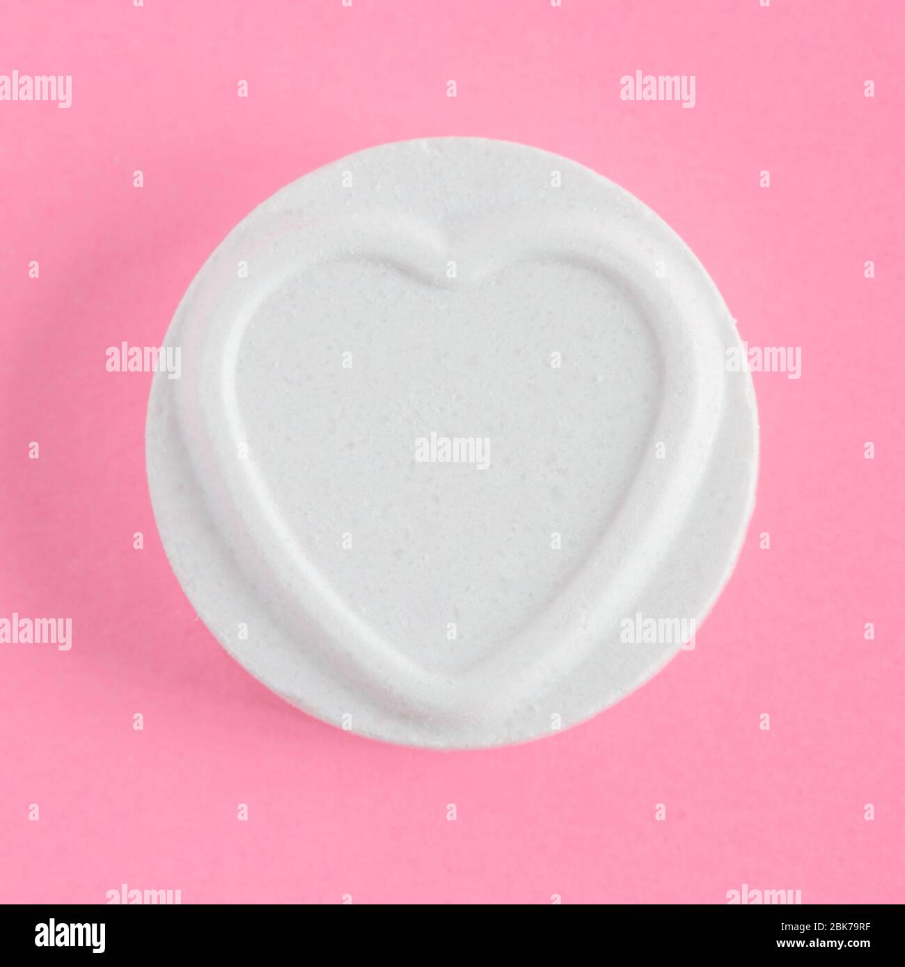 Un solo Amore cuori dolce o caramella in una cornice quadrata e uno sfondo rosa con spazio per copia Foto Stock