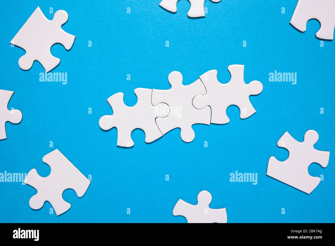 puzzle per il lavoro di squadra. Gioco di puzzle. Sfondo blu Foto Stock
