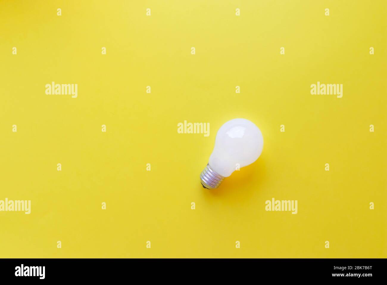 Lampadina bianca su sfondo giallo. Idea concetto, spazio di copia. Foto Stock