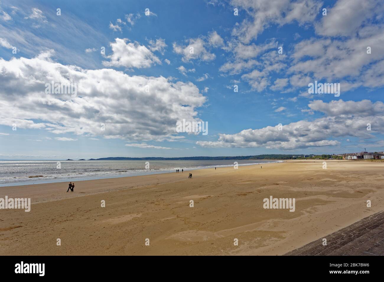 La gente cammina sulla spiaggia di Swansea Bay Foto Stock