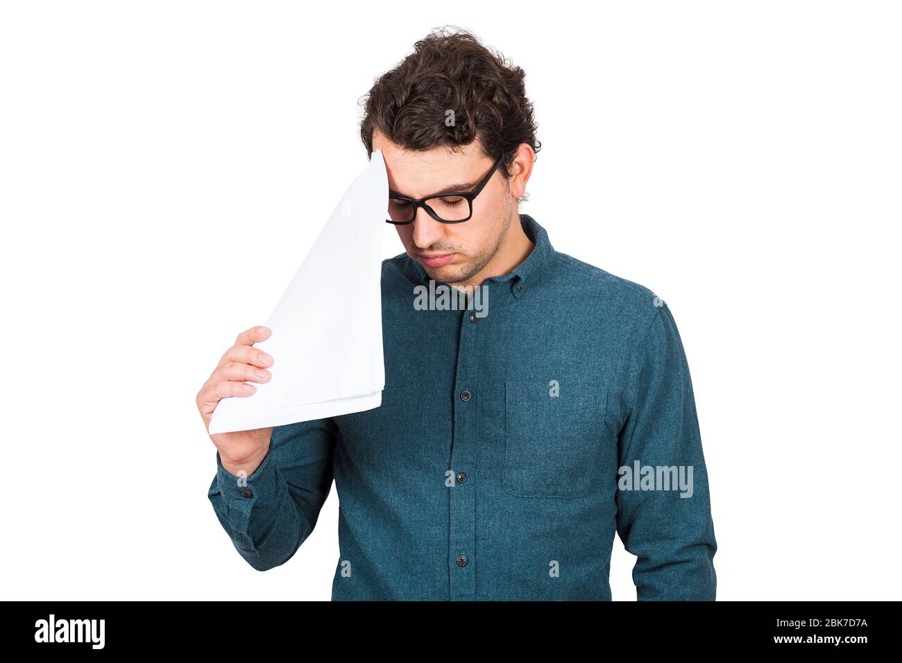 Un uomo d'affari pessimista che guarda giù sconvolto, come tiene diversi documenti cartacei isolati su sfondo bianco. Il lavoratore confuso di affari ha problemi, ne Foto Stock