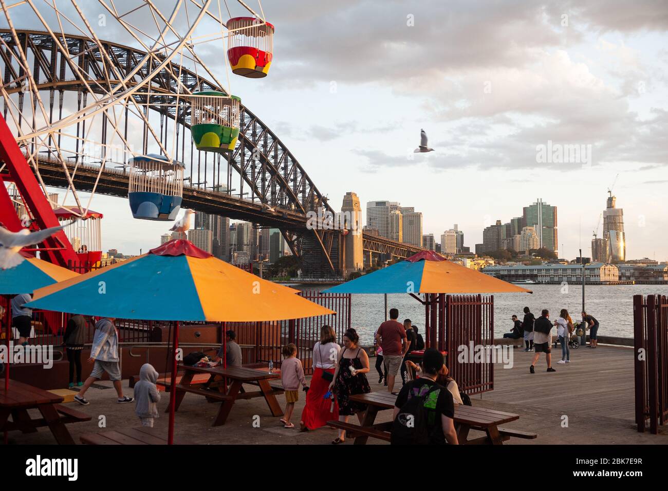 22.09.2019, Sydney, nuovo Galles del Sud, Australia - persone di fronte alla ruota panoramica al Luna Park FUNFair a Milsons Point con l'iconico Harbour Bridge. Foto Stock