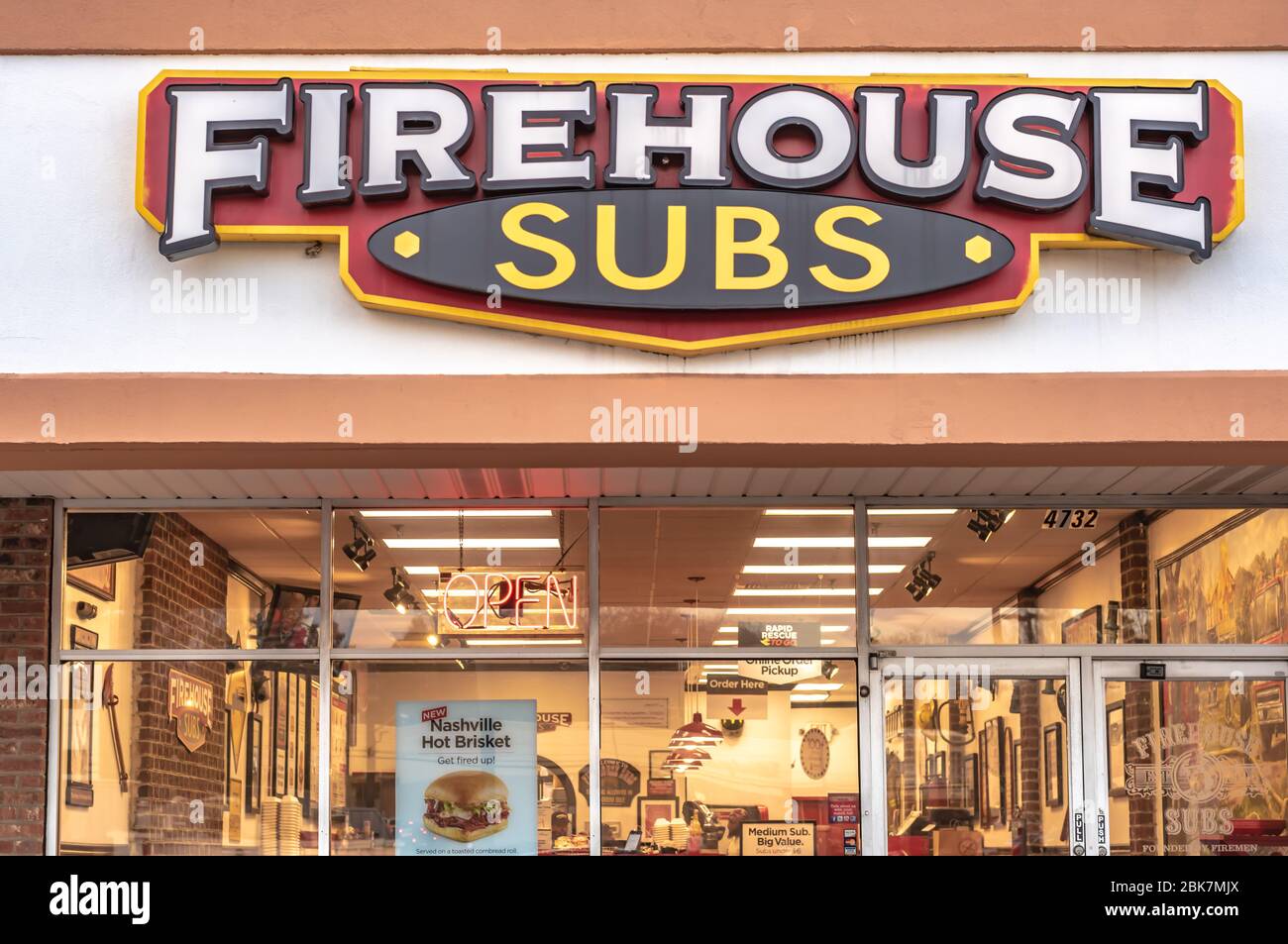 Charlotte, NC/USA - 26 dicembre 2019: Facciata del panino "Firehouse Subs" che mostra la segnaletica con marchio/logo e gli interni illuminati del ristorante. Foto Stock