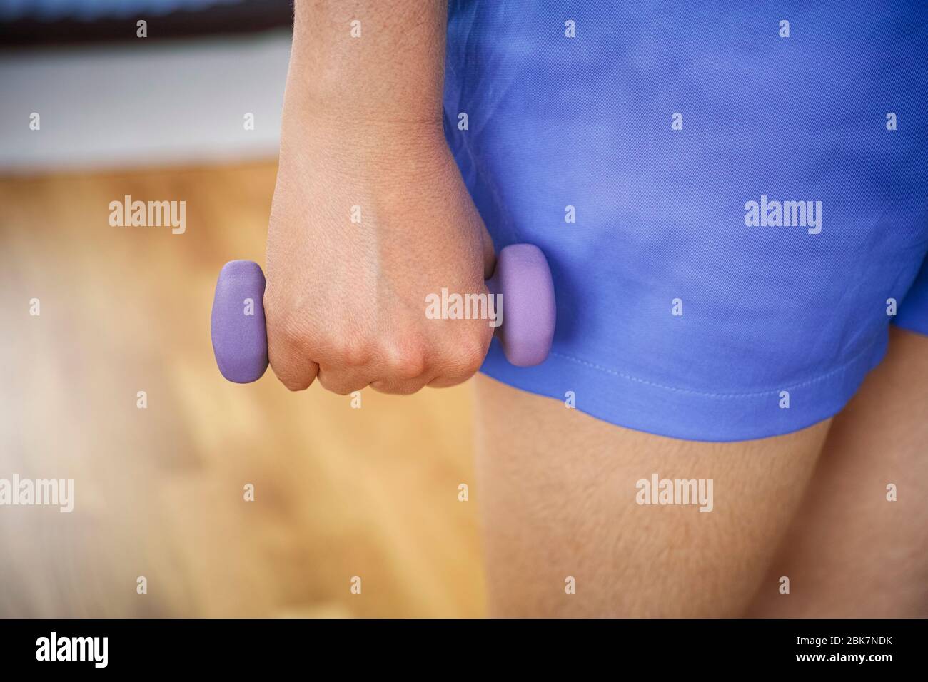 Donna che esercita con manubri a casa. Primo piano. Foto Stock