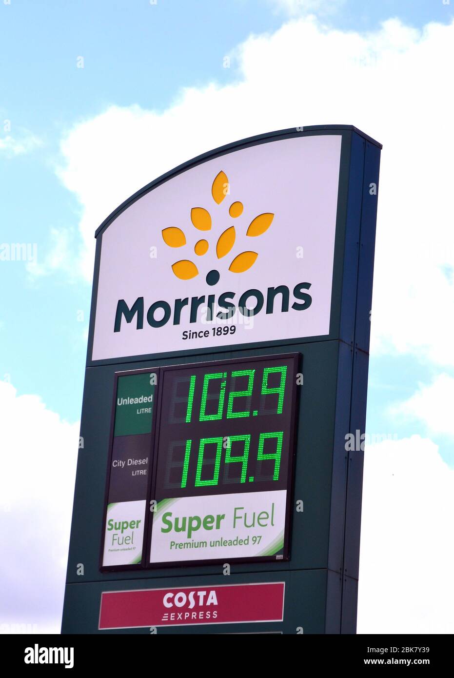 Morrisons distributore di benzina segno di prezzo a Manchester, Inghilterra, Regno Unito, mostrando scatenato a 102.9 penny un litro. I prezzi del petrolio sono diminuiti nella primavera del 2020. Foto Stock