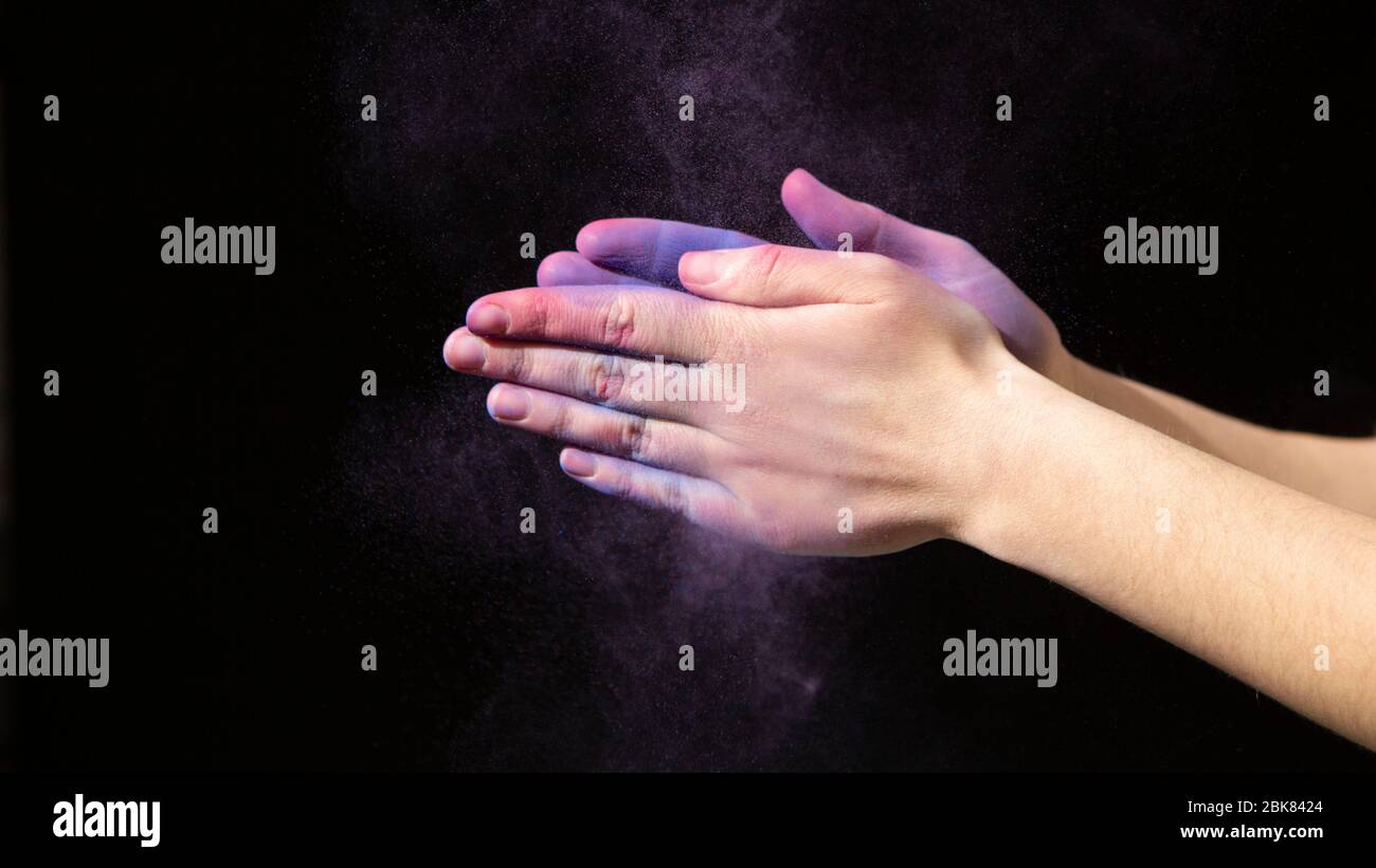 Vernice viola e mani su sfondo nero Foto Stock
