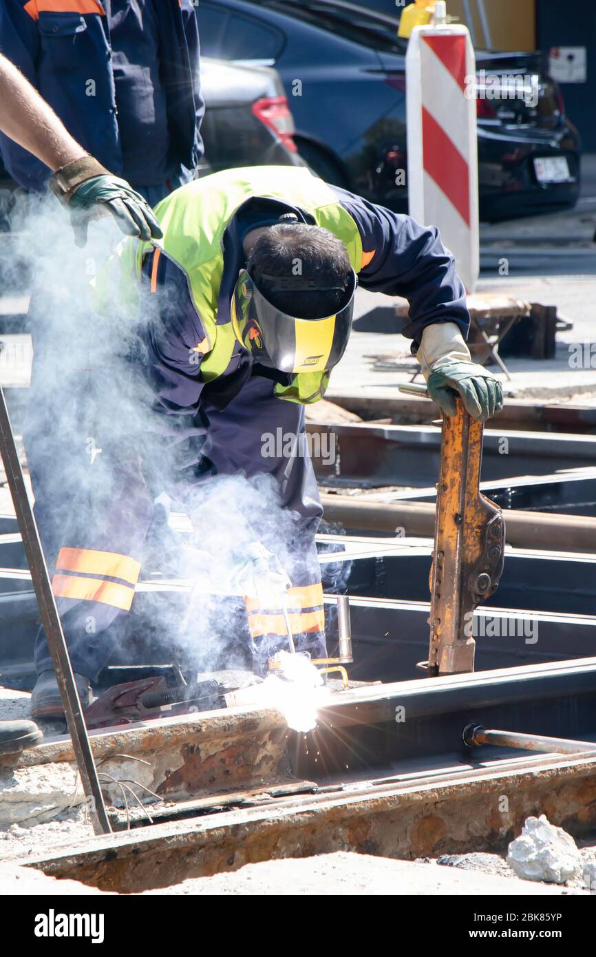 Belgrado, Serbia - 23 aprile 2020: Saldatore che lavora sul tram cittadino strada strada strada trasversale ferrovia, riparazione e sostituzione vecchi binari marcio Foto Stock