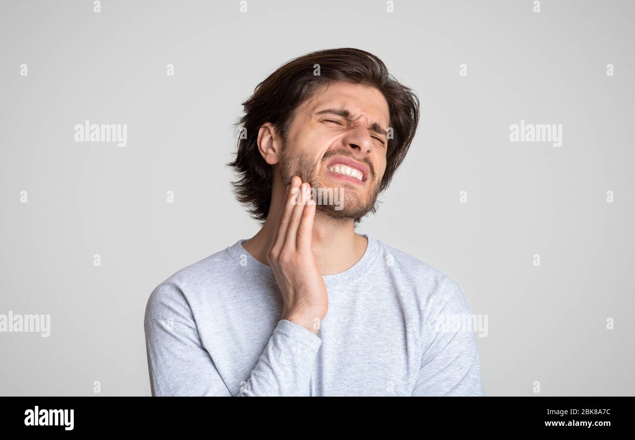 L'uomo sente dolore alla mandibola. Salute e cura dentale Foto Stock