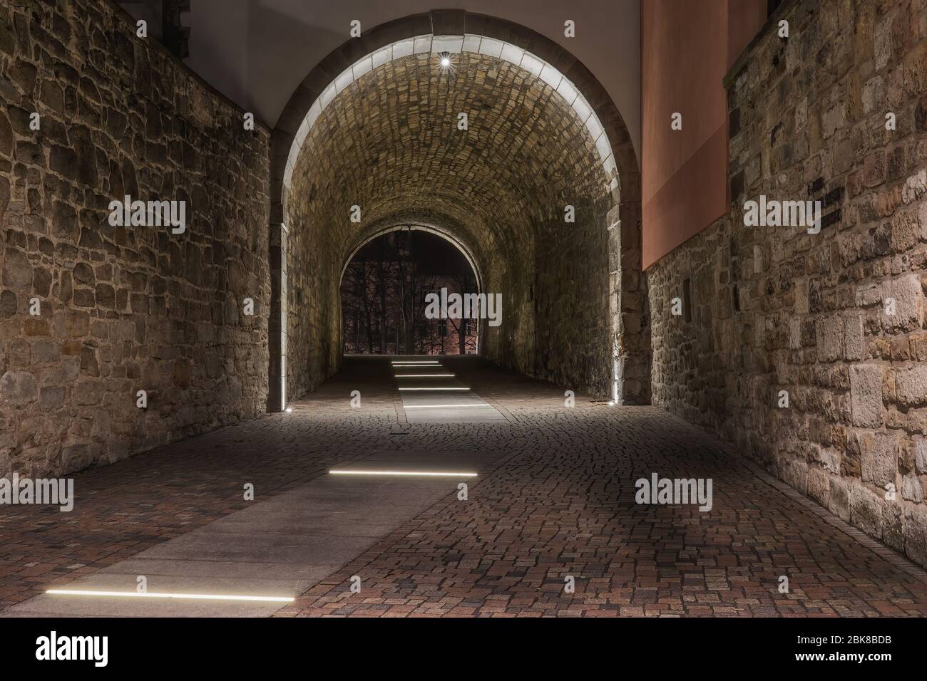 Un vecchio tunnel storico illuminato nella città vecchia e vecchie pietre sulle mura Foto Stock