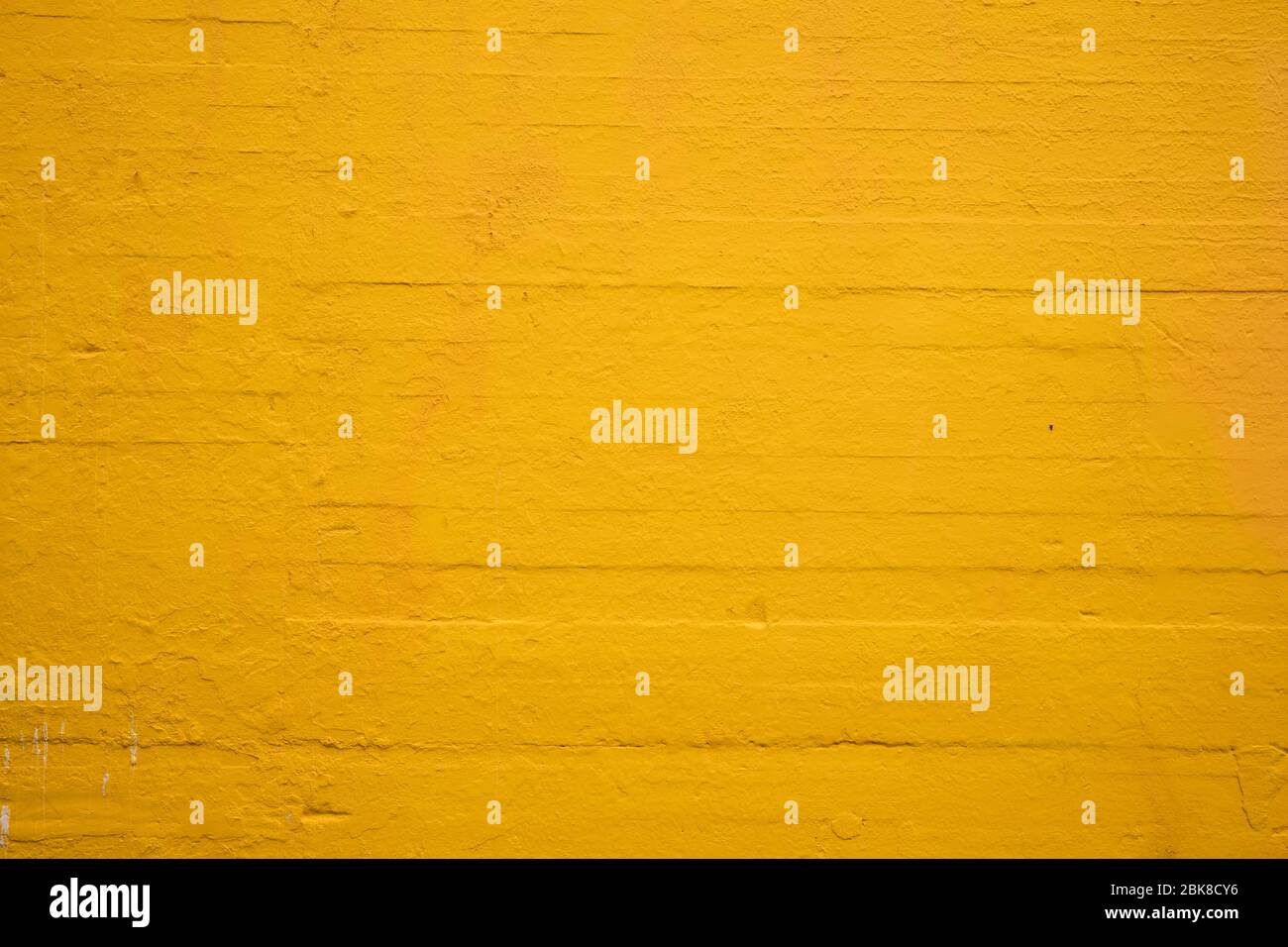 Textured parete in cemento dipinto di giallo girasole Foto Stock