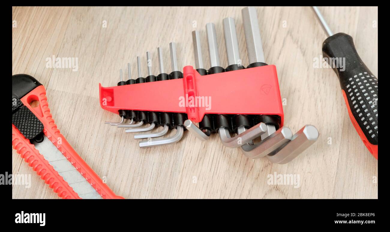 Worcker tiene in mano la chiave esagonale nei guanti. Primo piano. Foto Stock