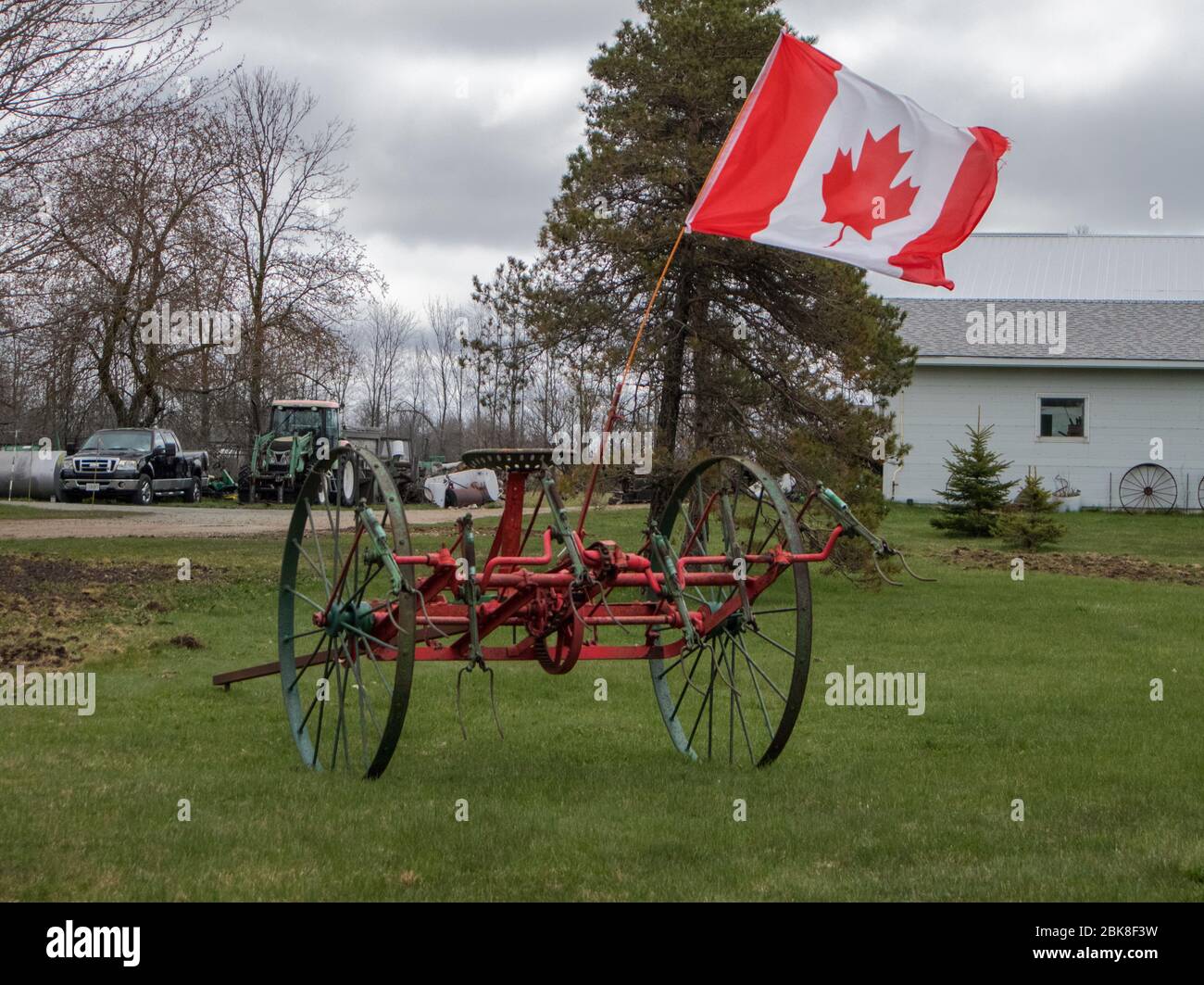 Un antico aratro trainato da cavalli, orgogliosamente battenti la bandiera canadese. Foto Stock