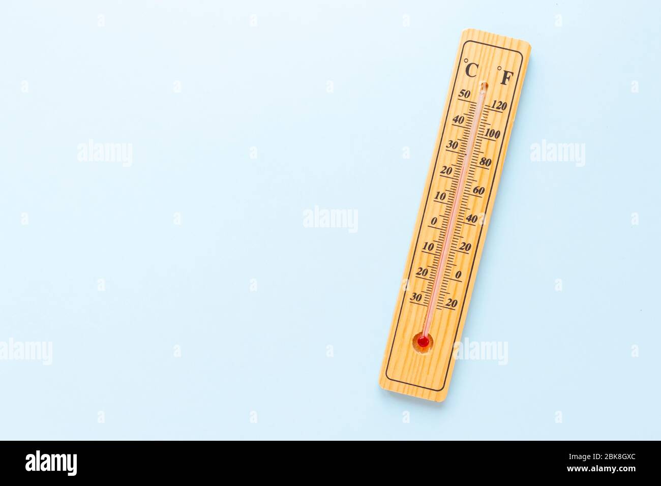 Un classico termometro in legno su sfondo blu non mostra alcuna temperatura. Spazio di copia Foto Stock