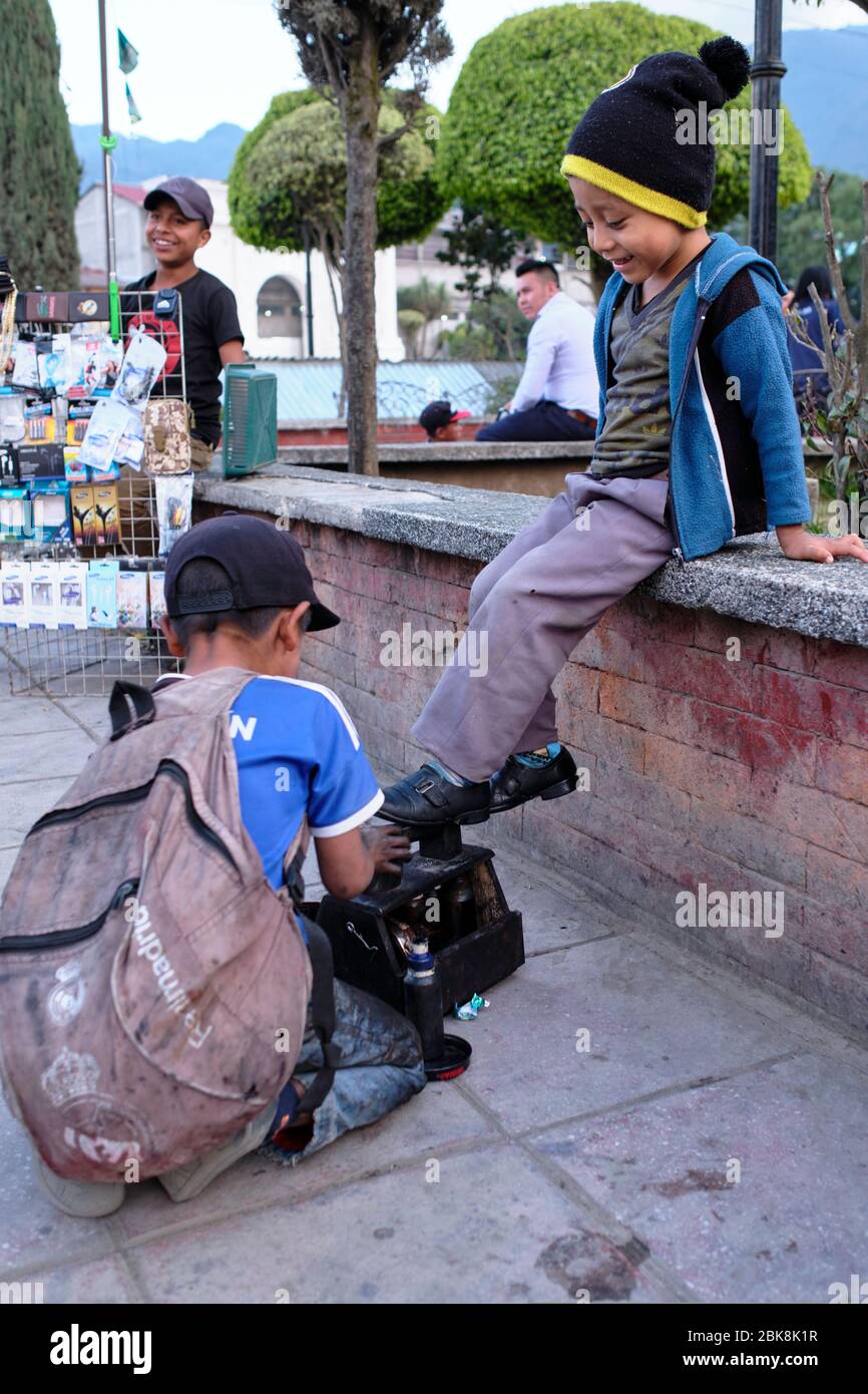 Shoe Shine boy pulizia scarpe da ragazzo nella piazza principale di Nebaj. Foto Stock