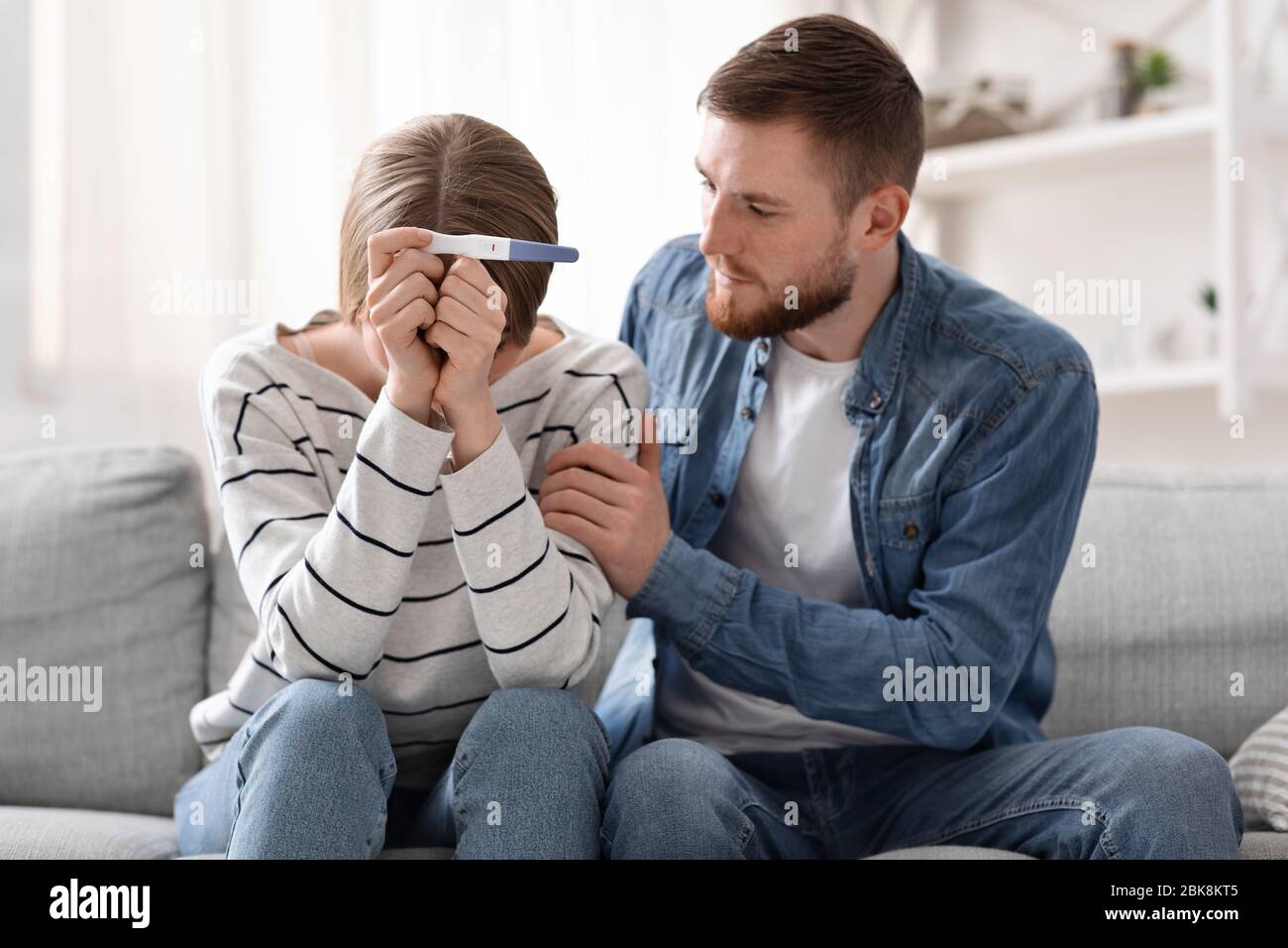 Coppia turbata seduta con esito negativo del test di gravidanza Foto Stock