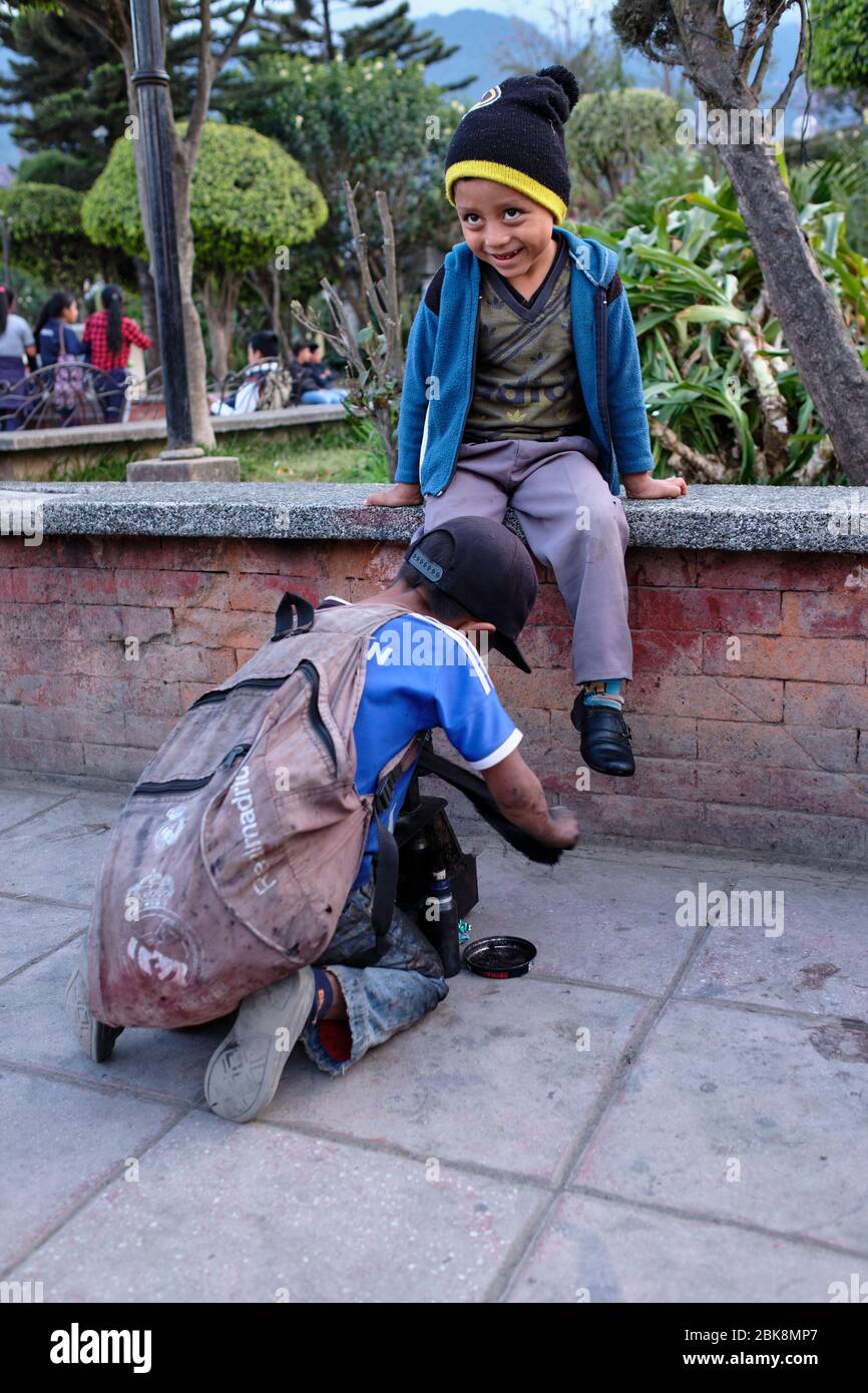 Shoe Shine boy pulizia scarpe da ragazzo nella piazza principale di Nebaj. Foto Stock