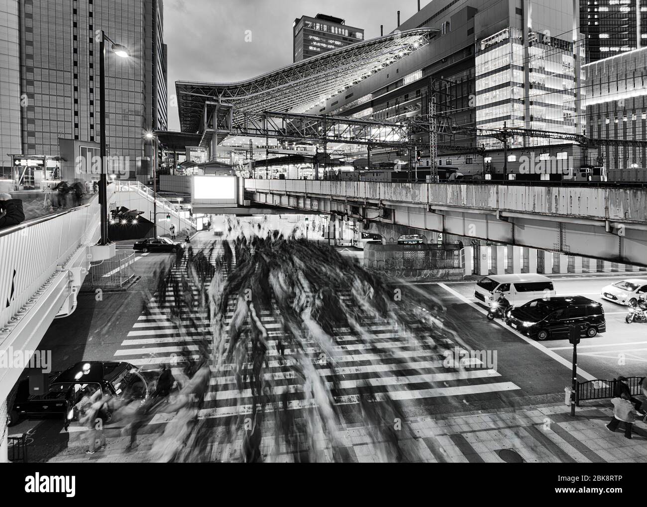 Tramonto nero-bianco scuro intorno all'affollata traversata di strada nella città di Osaka vicino alla stazione ferroviaria umeda di Osaka. Foto Stock