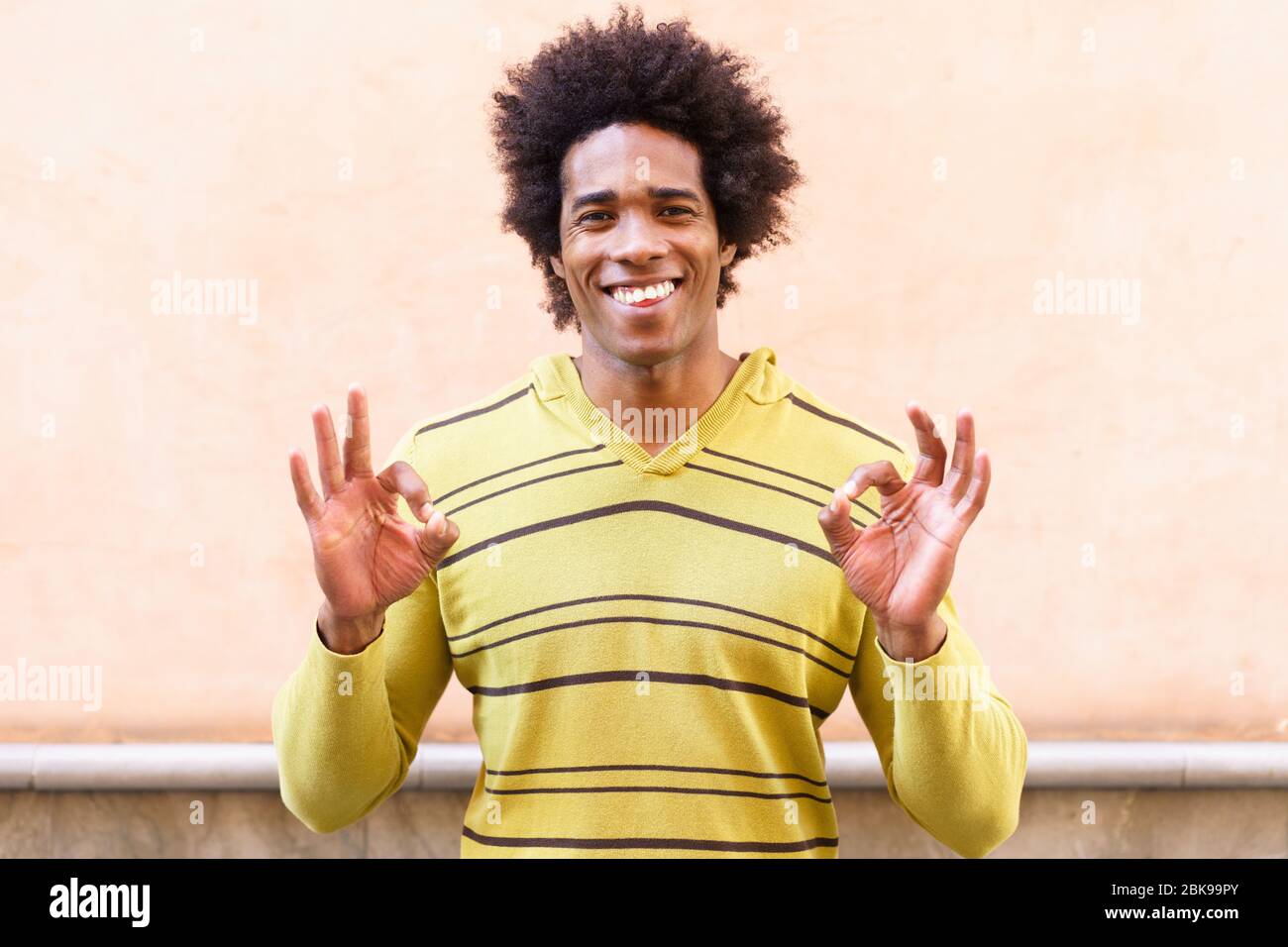 Uomo nero con i capelli afro che mette un'espressione divertente Foto Stock