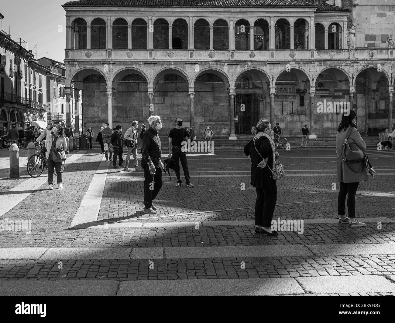 Cremona, Lombardia, Italia - 2 maggio 2020 - coda di persone per accedere al mercato alimentare aperto , accesso controllato da ufficio di polizia che esegue la scansione per il test della febbre Foto Stock