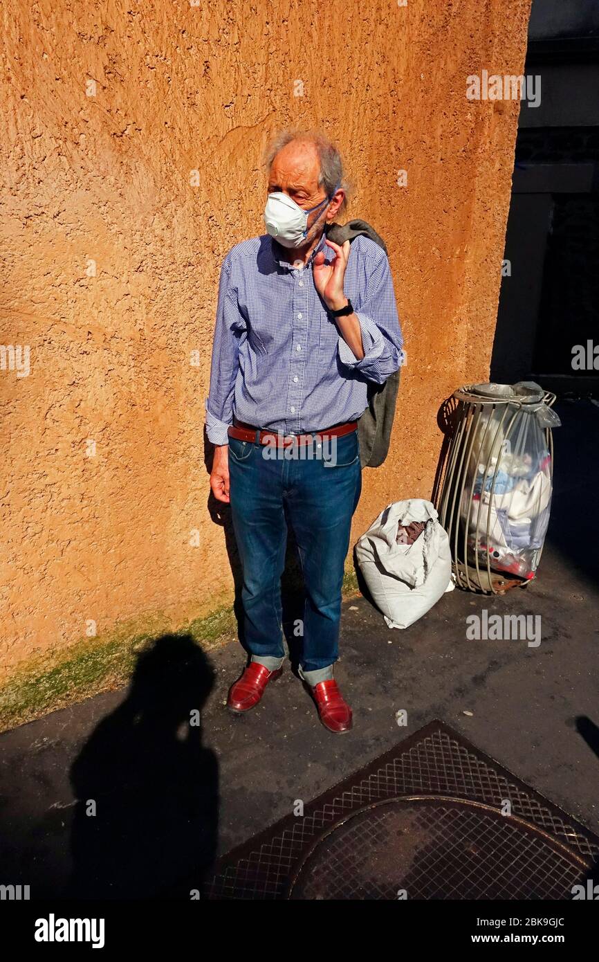 Uomo, Senior con maschera accanto al cestino, quarantena, coprifuoco, Corona, Covid-19, Parigi, Francia Foto Stock