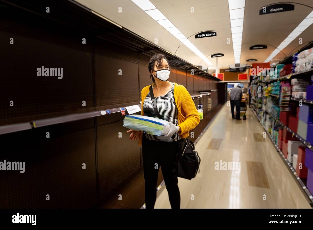La donna cerca disperatamente i rifornimenti e i prodotti di carta durante la scarsità epidemica. Foto Stock