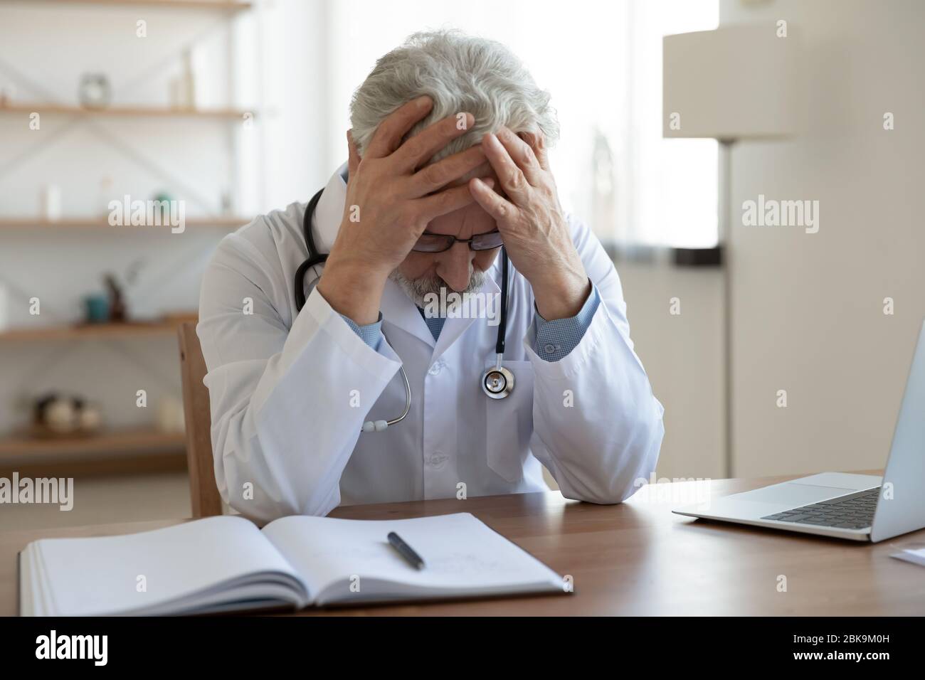 Stanco depresso medico maschile si sente disperato pensare al problema Foto Stock