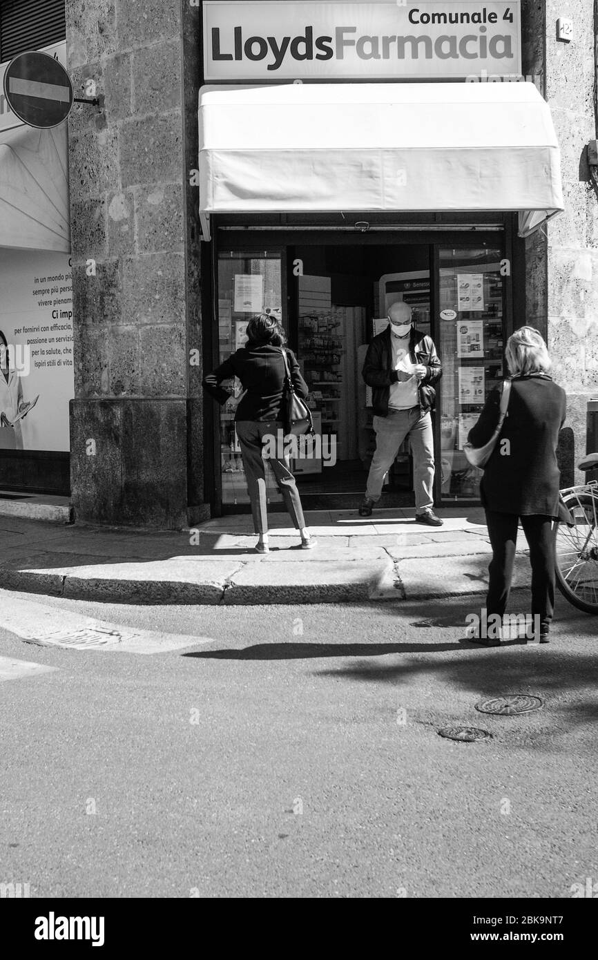 Cremona, Lombardia, Italia - 2020 maggio le persone si accodano fuori dalla farmacia Lloyds , le persone si sono messe in coda per entrare una volta per volta, in quanto si applicano nuove regole Foto Stock