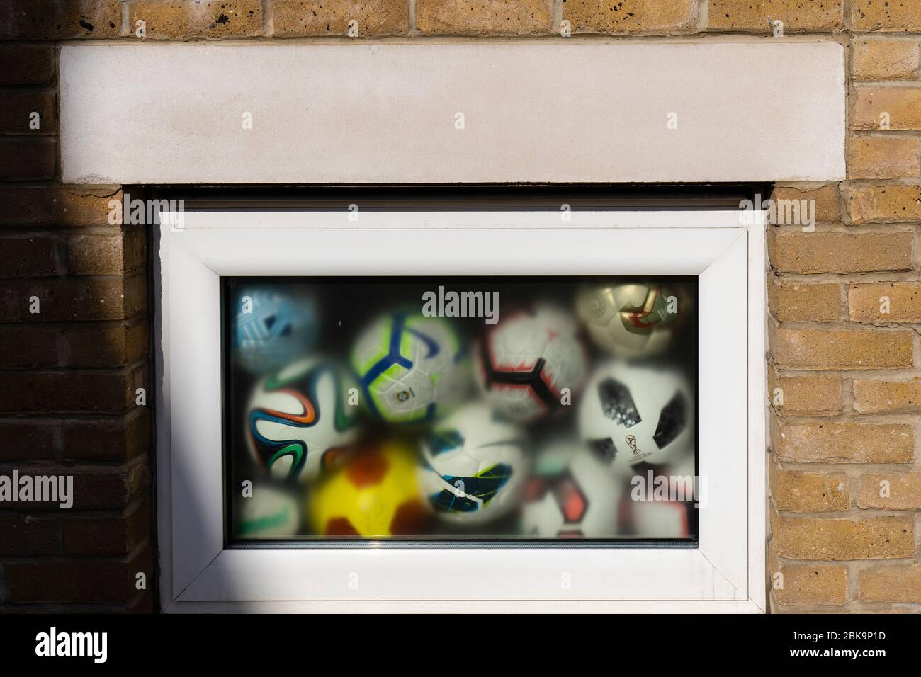 Lockdown London: Palloni da calcio si schiantarono contro una finestra di un edificio vicino al Tamigi a Putney. Foto Stock