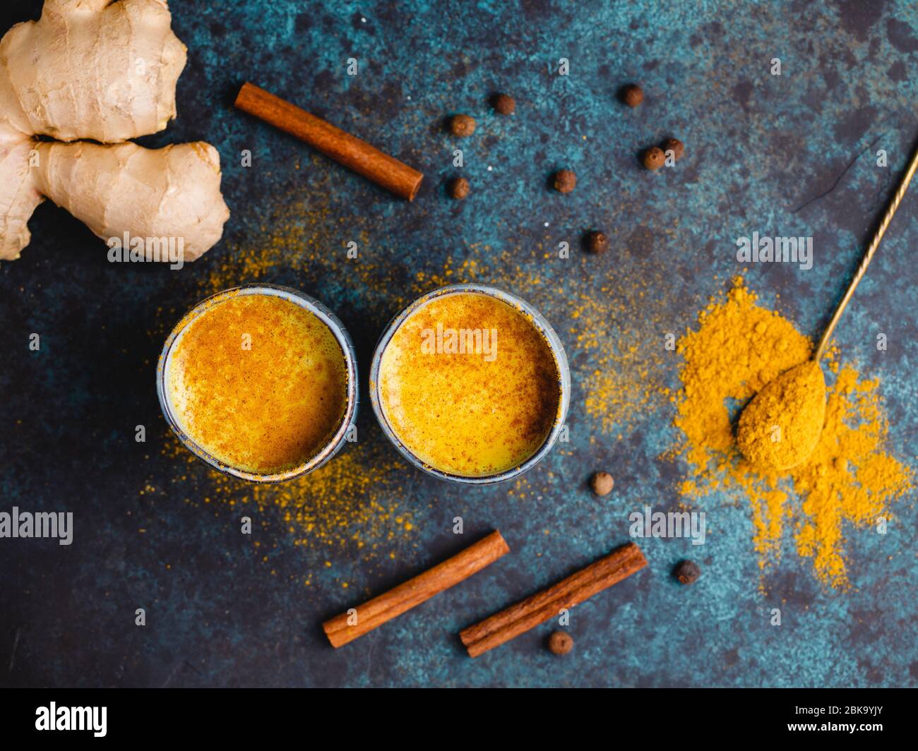 Vista dall'alto del latte curcuma, zenzero, cannella e allspezia. Bevanda immune e sanitaria. Foto Stock