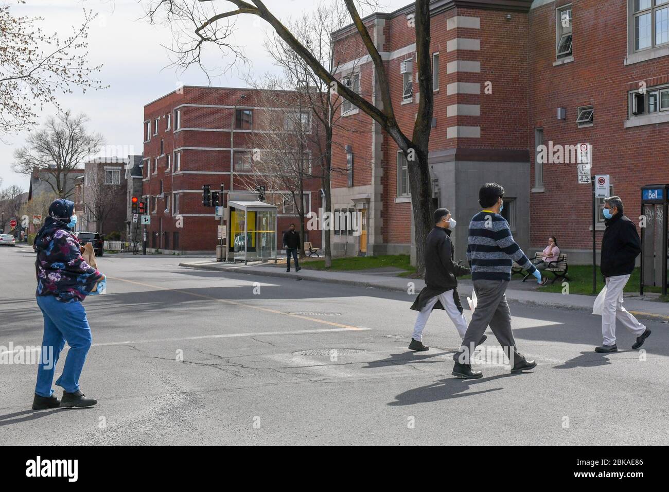 Pedoni che indossano maschere facciali nel quartiere immigrato di estensione parco, Coronavirus Pandemic Foto Stock