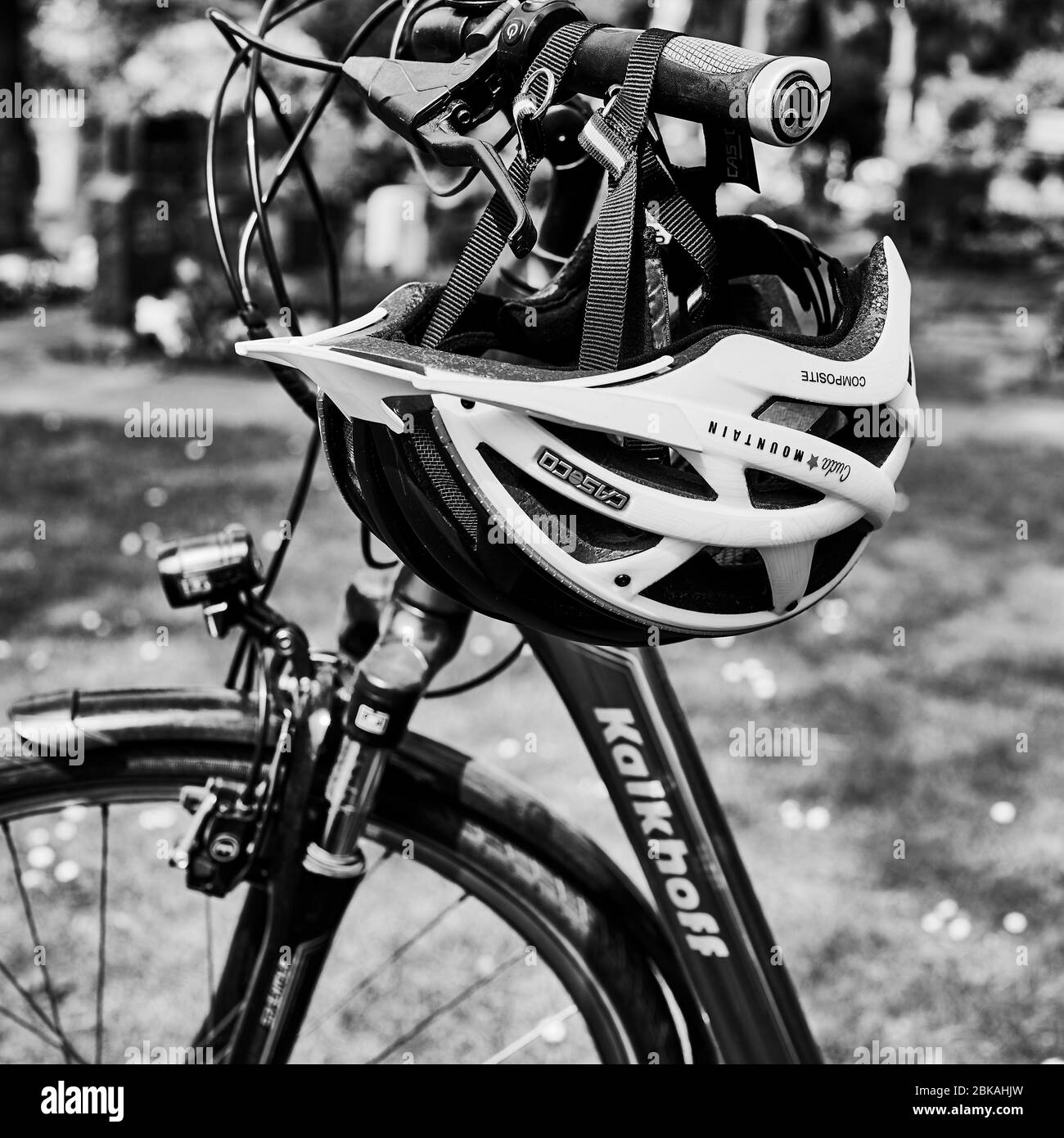 Berlino, Germania - 28 aprile 2020: Foto in bianco e nero di un casco per bicicletta appeso su un manubrio per bicicletta. Foto Stock