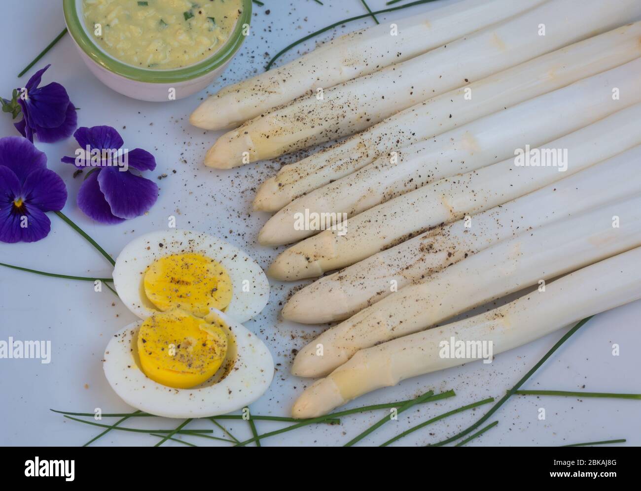 Mazzo di asparagi bianchi freschi non cotti e uova sode, raccolta nuova, primo piano. Effetto filtro. Verdure di stagione. Messa a fuoco selettiva Foto Stock