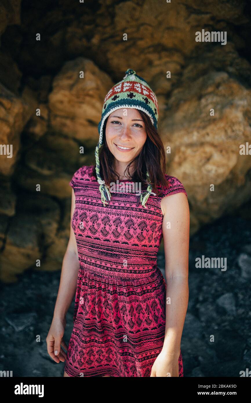 ragazza con diversi cappelli su uno sfondo di rocce gialle Foto Stock