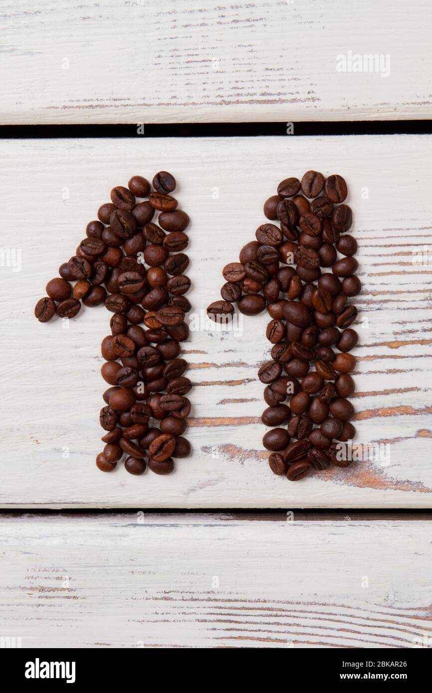 Caffè marrone in grani disposti a forma di undici. Foto Stock