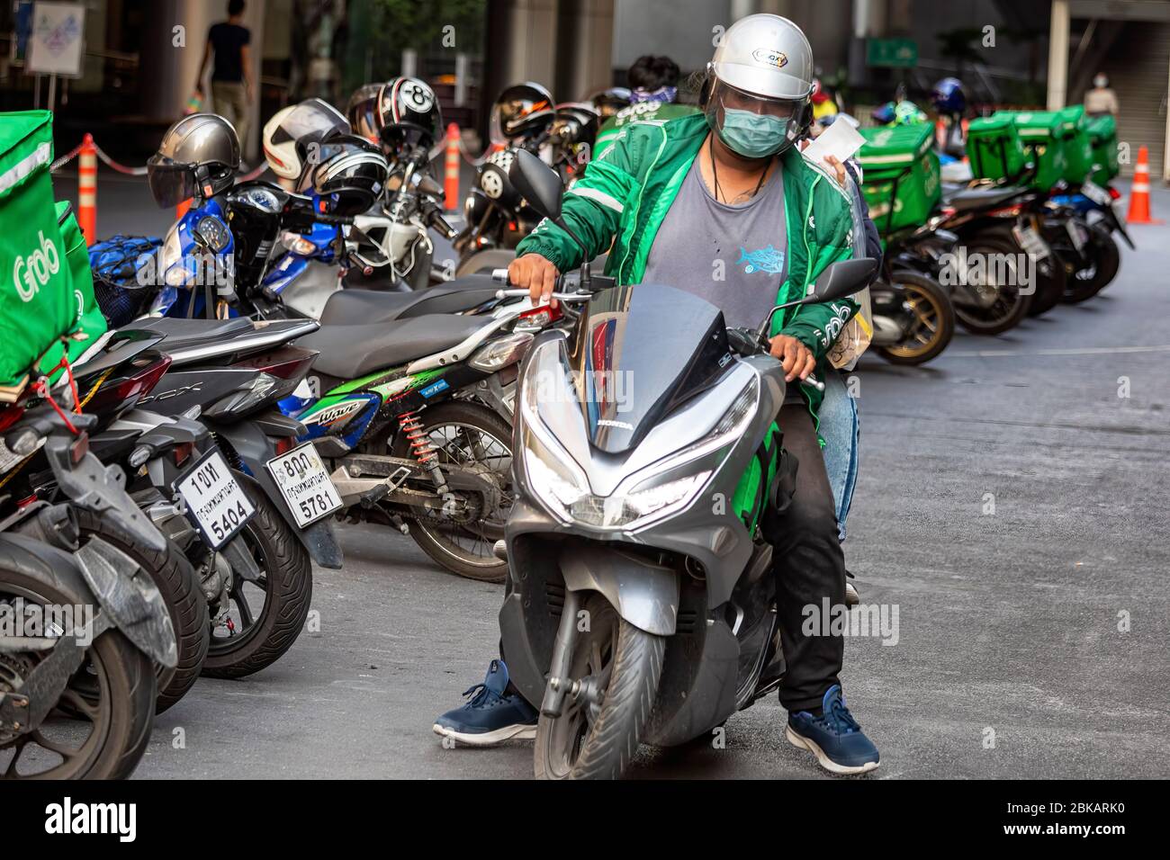 Afferra i piloti di moto che indossano maschera facciale durante la pandemia Covid 19, Bangkok, Thailandia Foto Stock