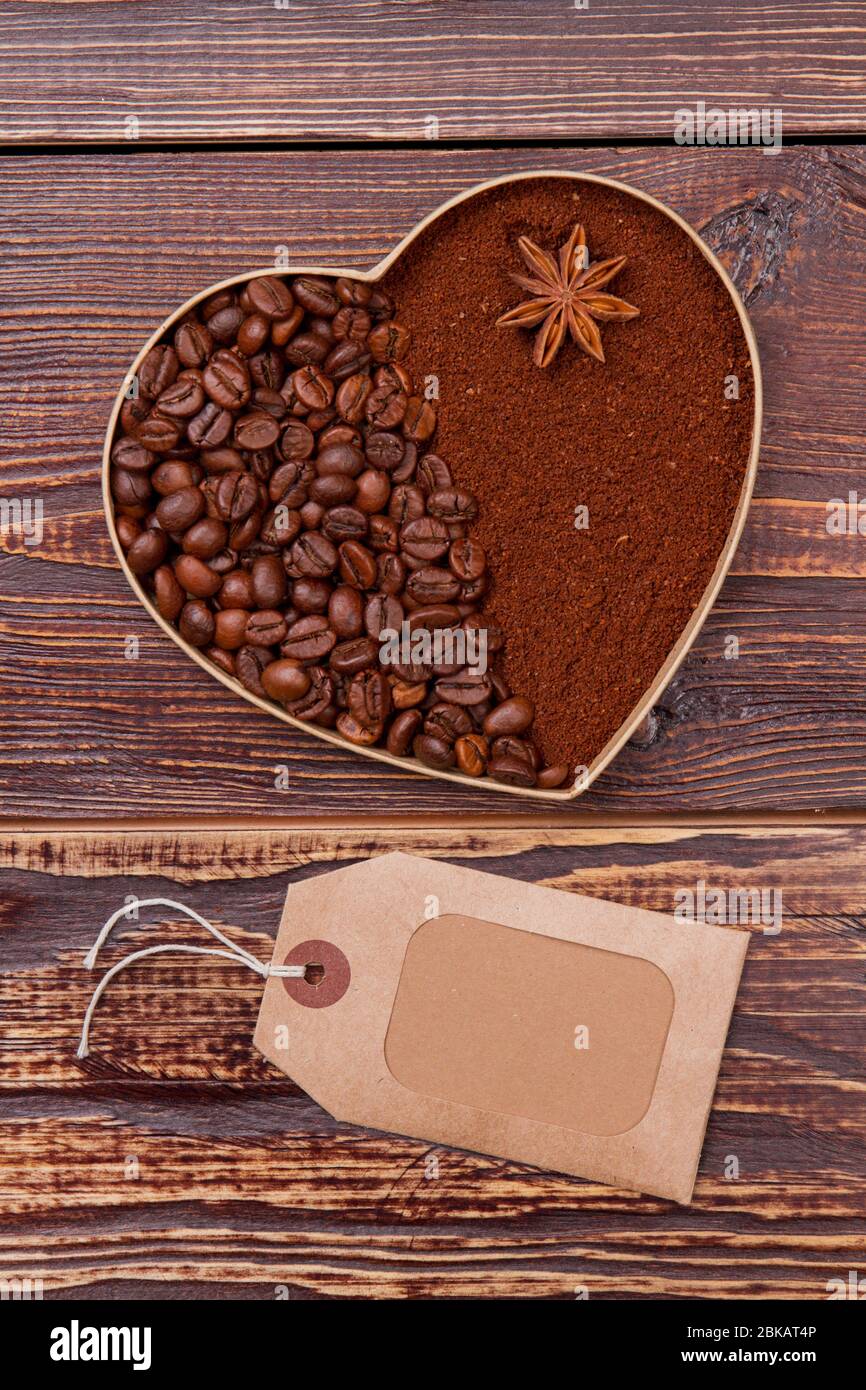 Cuore creato di caffè in chicchi e caffè istantaneo su sfondo di legno. Foto Stock