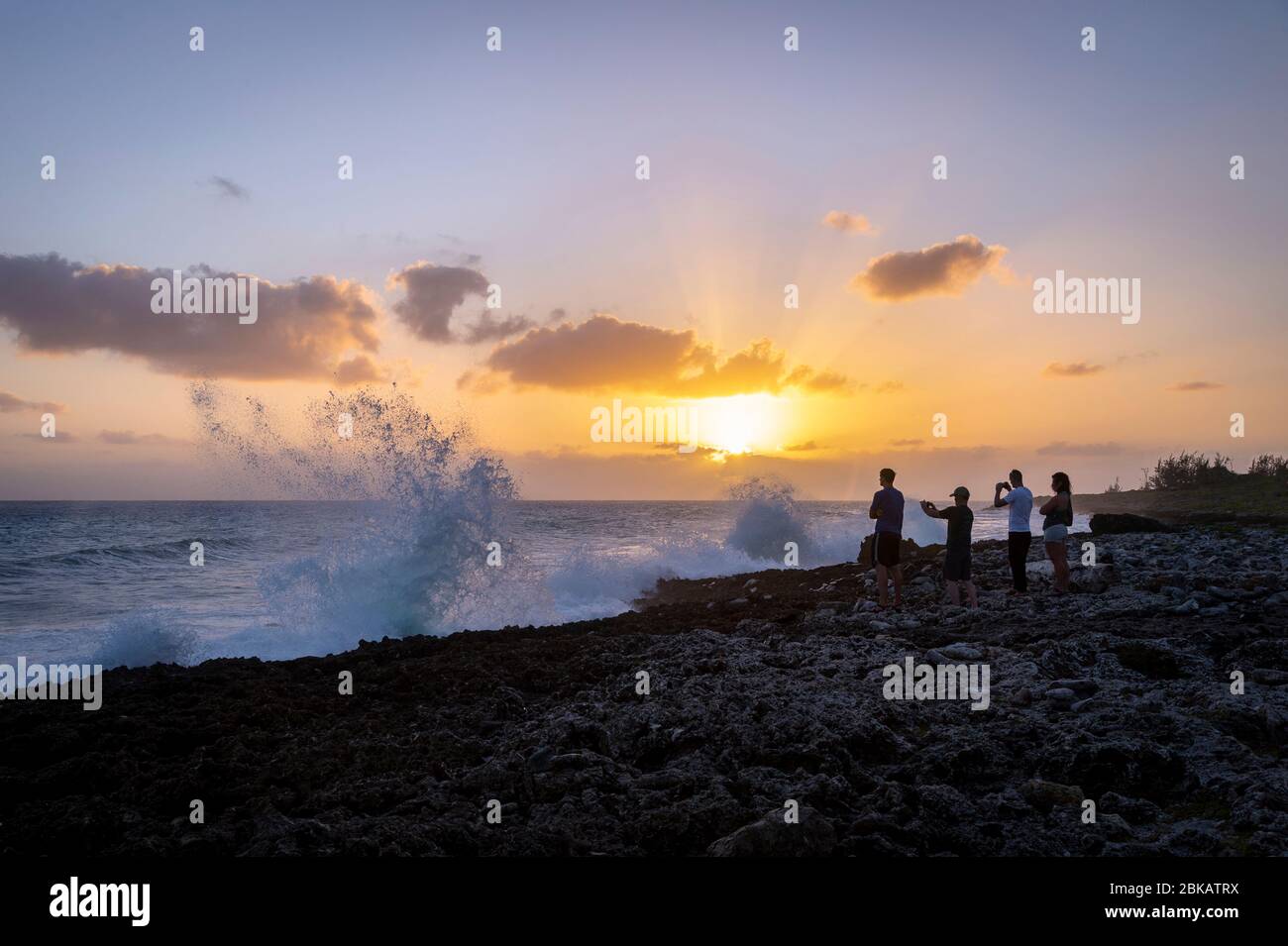 Grandi onde che si schiantano contro le rocce con la gente che guarda, Grand Cayman Island Blowhole Foto Stock