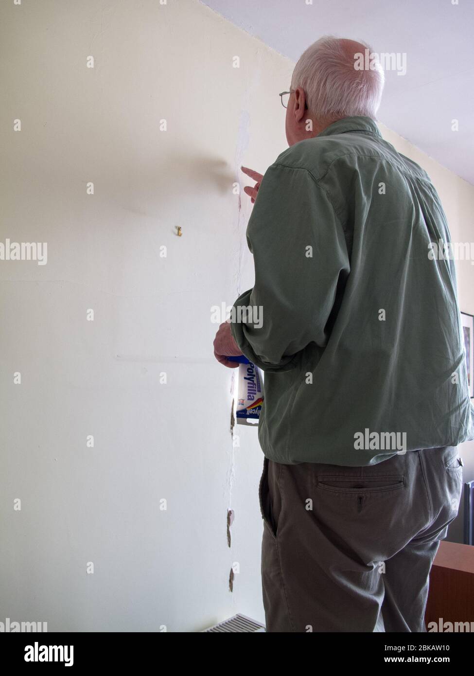 Uomo di 72 anni che fa la preparazione della decorazione con Polyfilla in una casa Oxford durante la pandemia COVID-19 Foto Stock