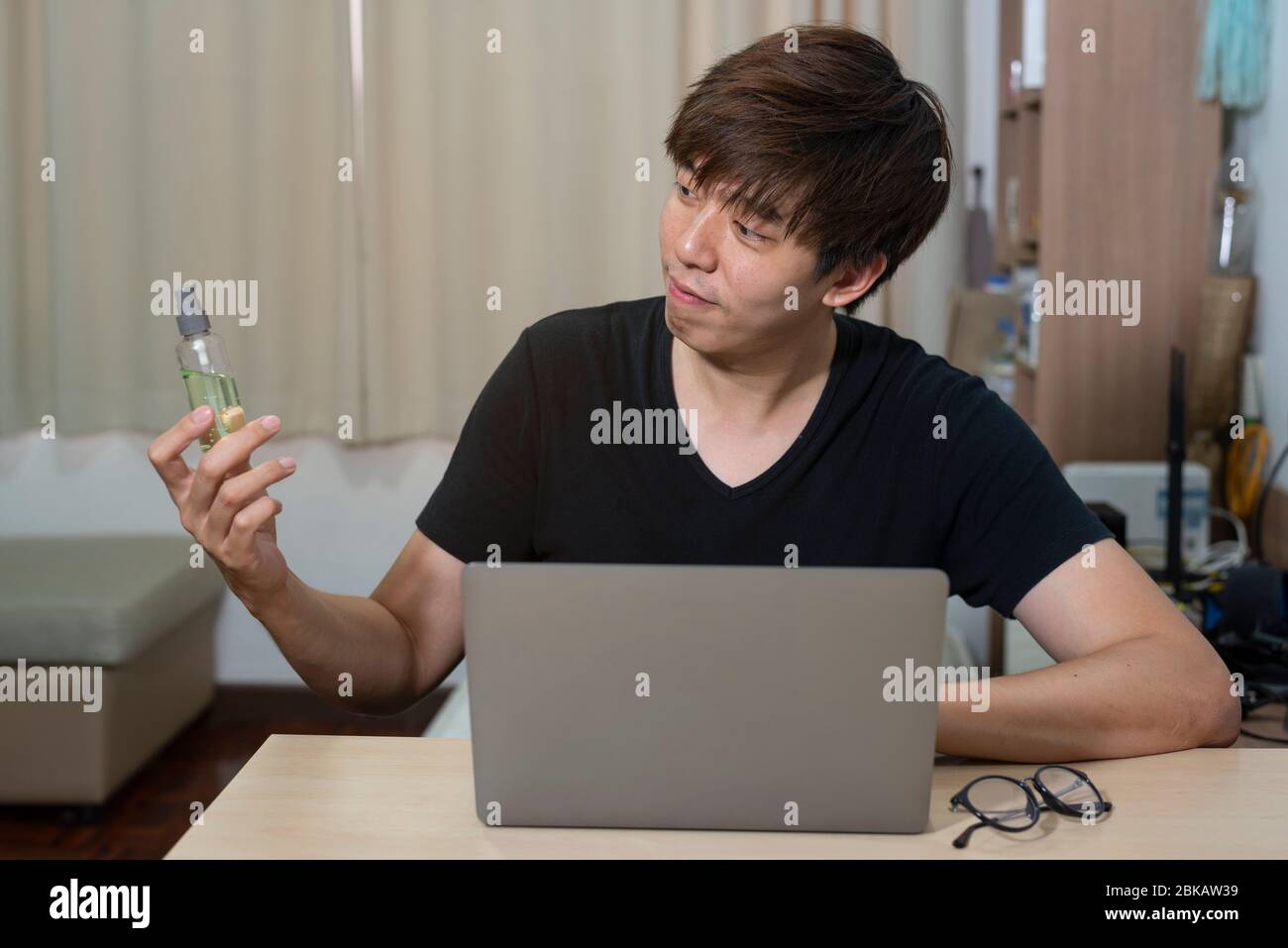 L'uomo ufficiale asiatico lavora da casa. L'uomo lavora in azione a casa. Uomo con notebook che lavora in remoto tramite connessione internet ad alta velocità. Tecnologia di comunicazione Foto Stock