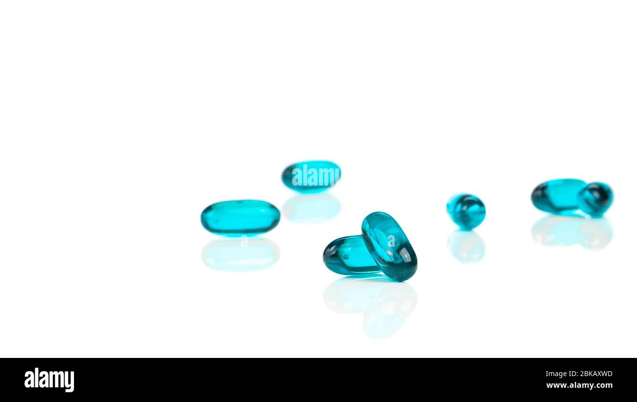 Primo piano delle capsule di gel morbido blu su sfondo bianco - integratori medici Foto Stock