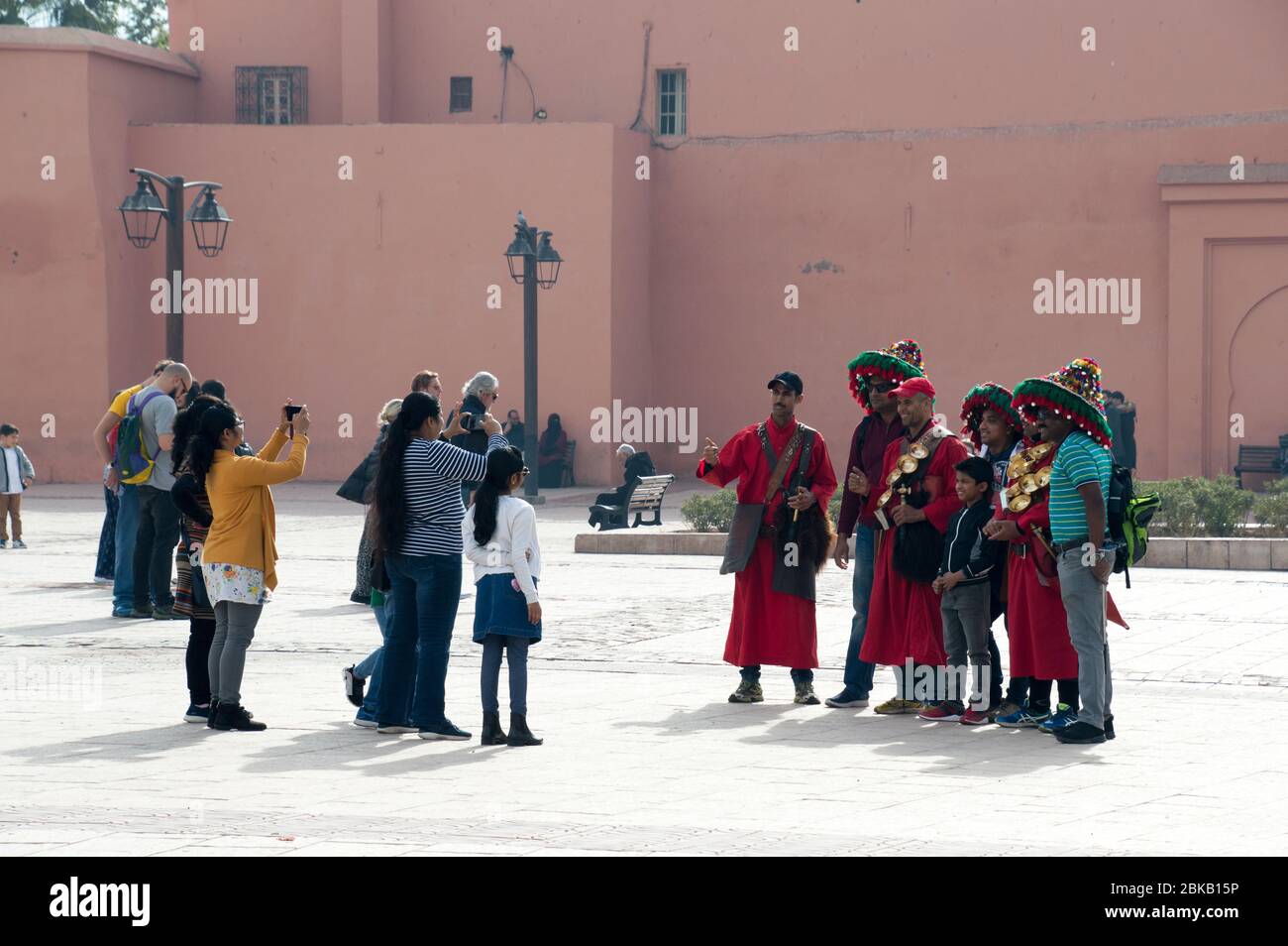 Turisti che posano con i venditori tradizionali di acqua nella città di Marrakech (Marrakech), Marocco, Nord Africa Foto Stock