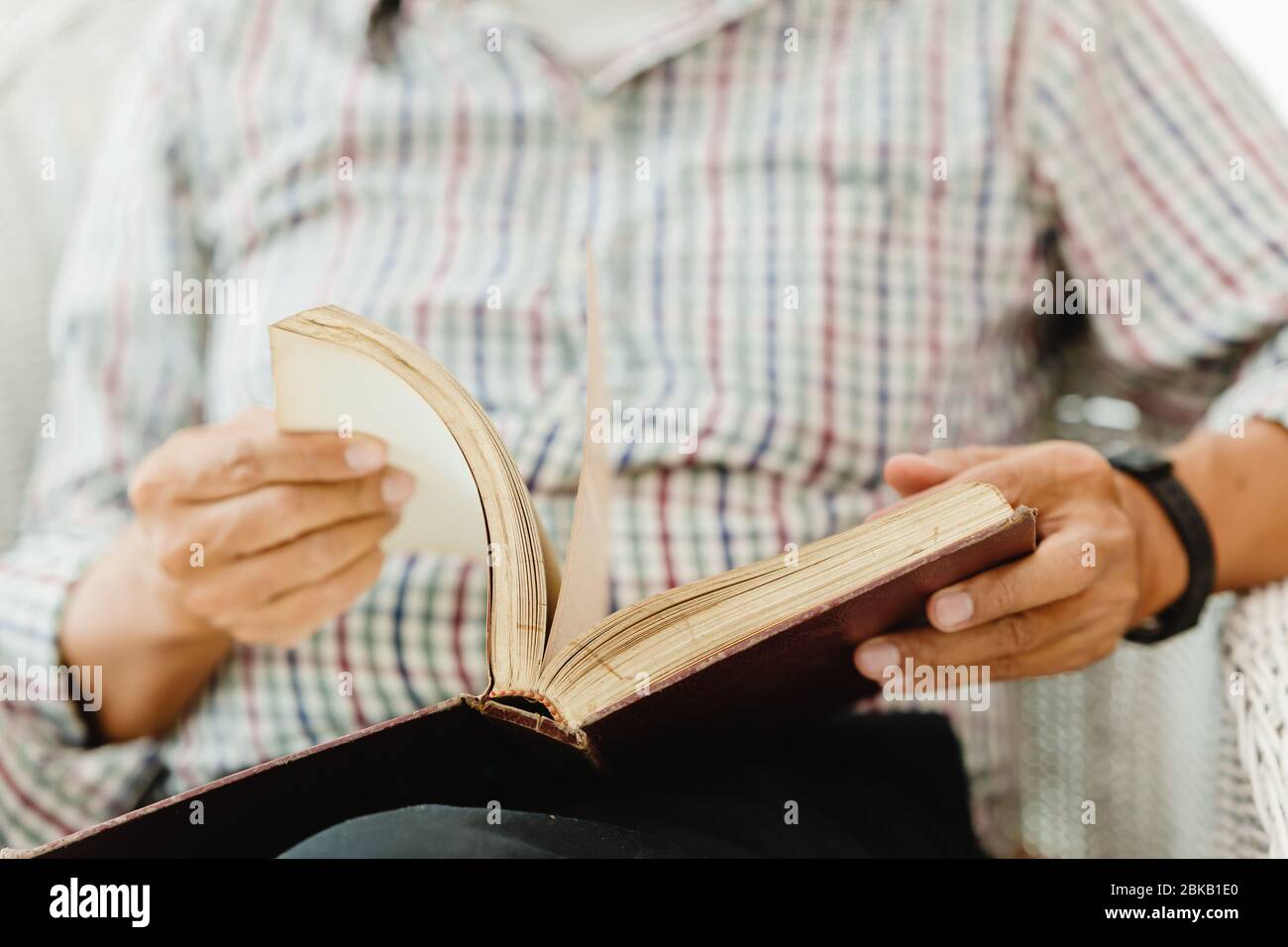 Primo piano mano anziano apertura lettura di un libro Foto Stock
