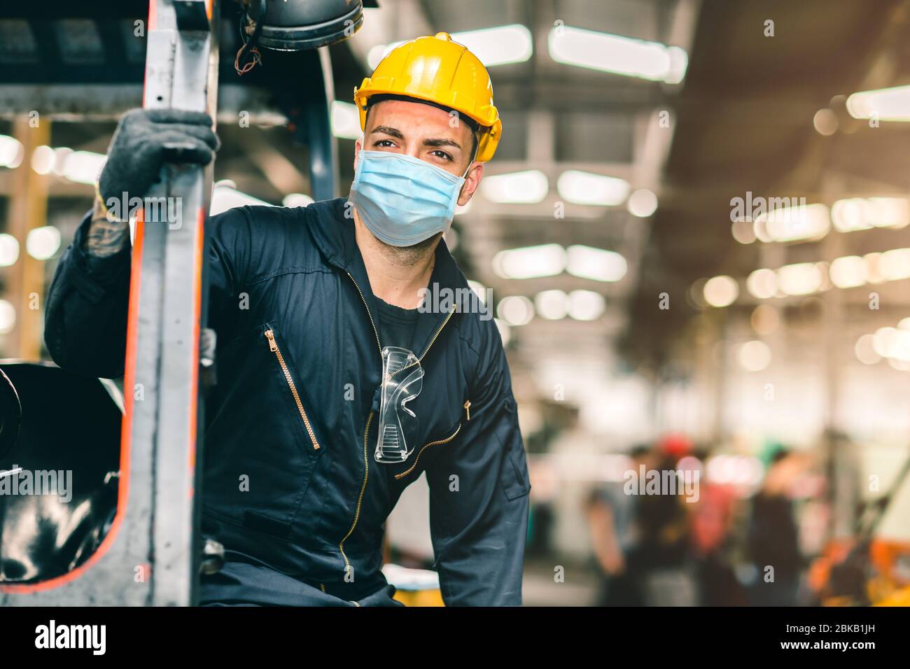 Gli operai indossano una maschera facciale monouso per la protezione Corona Virus spreading e il filtro per l'inquinamento dell'aria da polvere di fumo in fabbrica per una cura del lavoro sana. Foto Stock