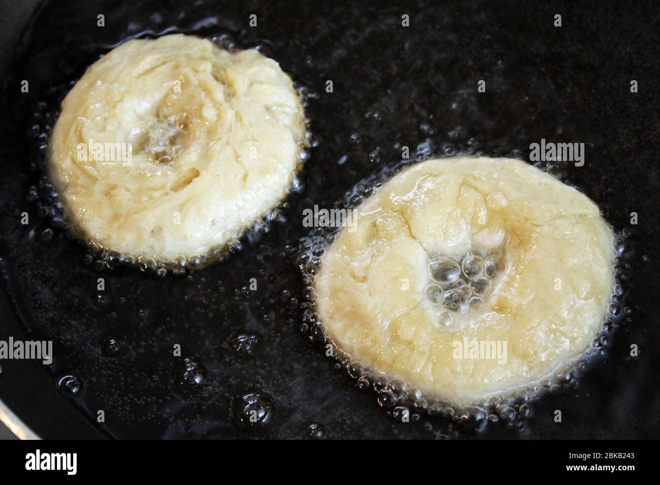 Anello Donuts cottura in olio Foto Stock
