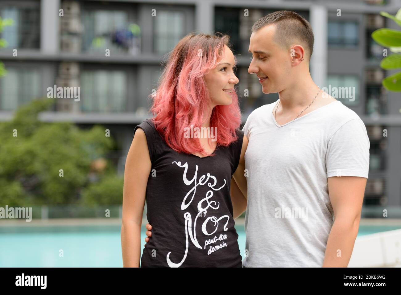 Ritratto di una coppia felice che si guarda l'un l'altro nell'area piscina Foto Stock
