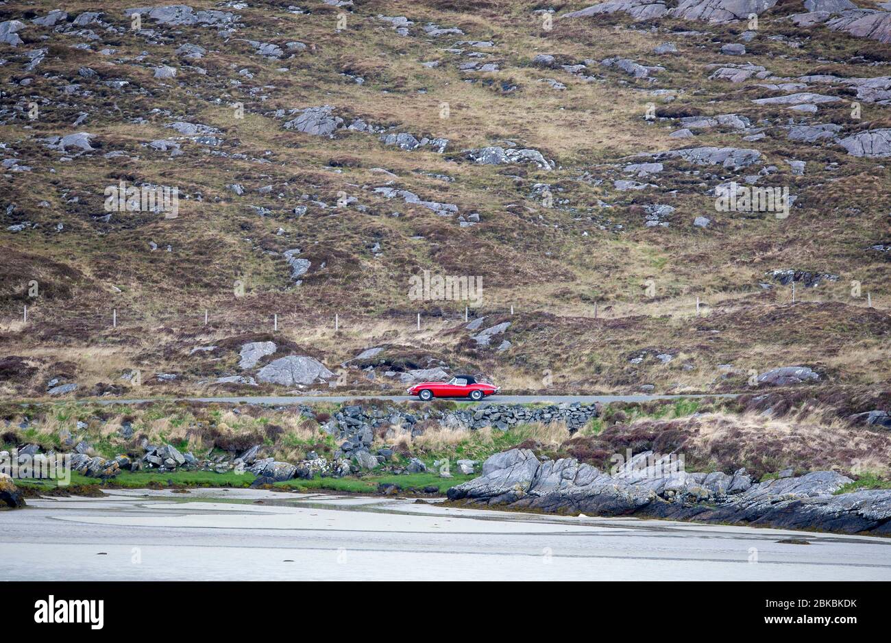 Jaguar e-Type sulla strada per Hushinish, Isola di Harris, Ebridi esterne, Scozia. Foto Stock
