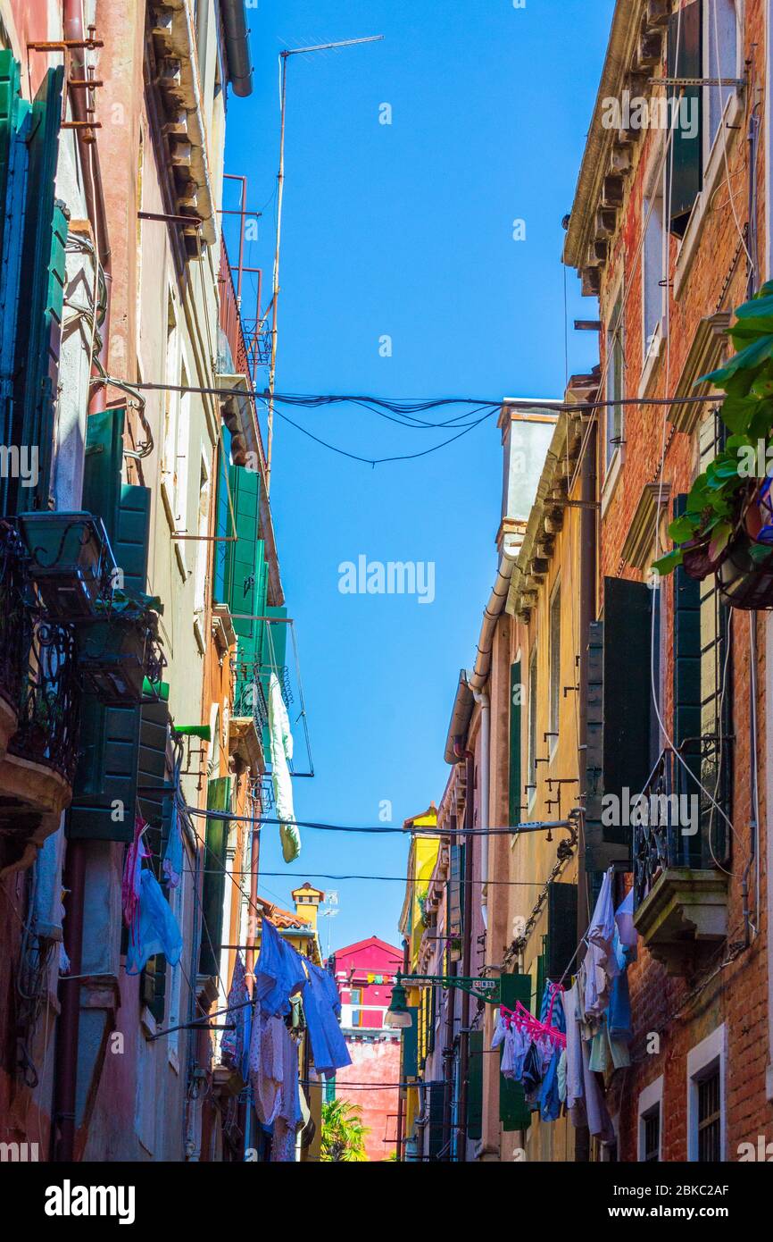 Vestiti lavati asciugandosi fuori su una corda tesa tra vecchie case storiche sopra strada stretta, Venezia,Veneto,Italia Foto Stock