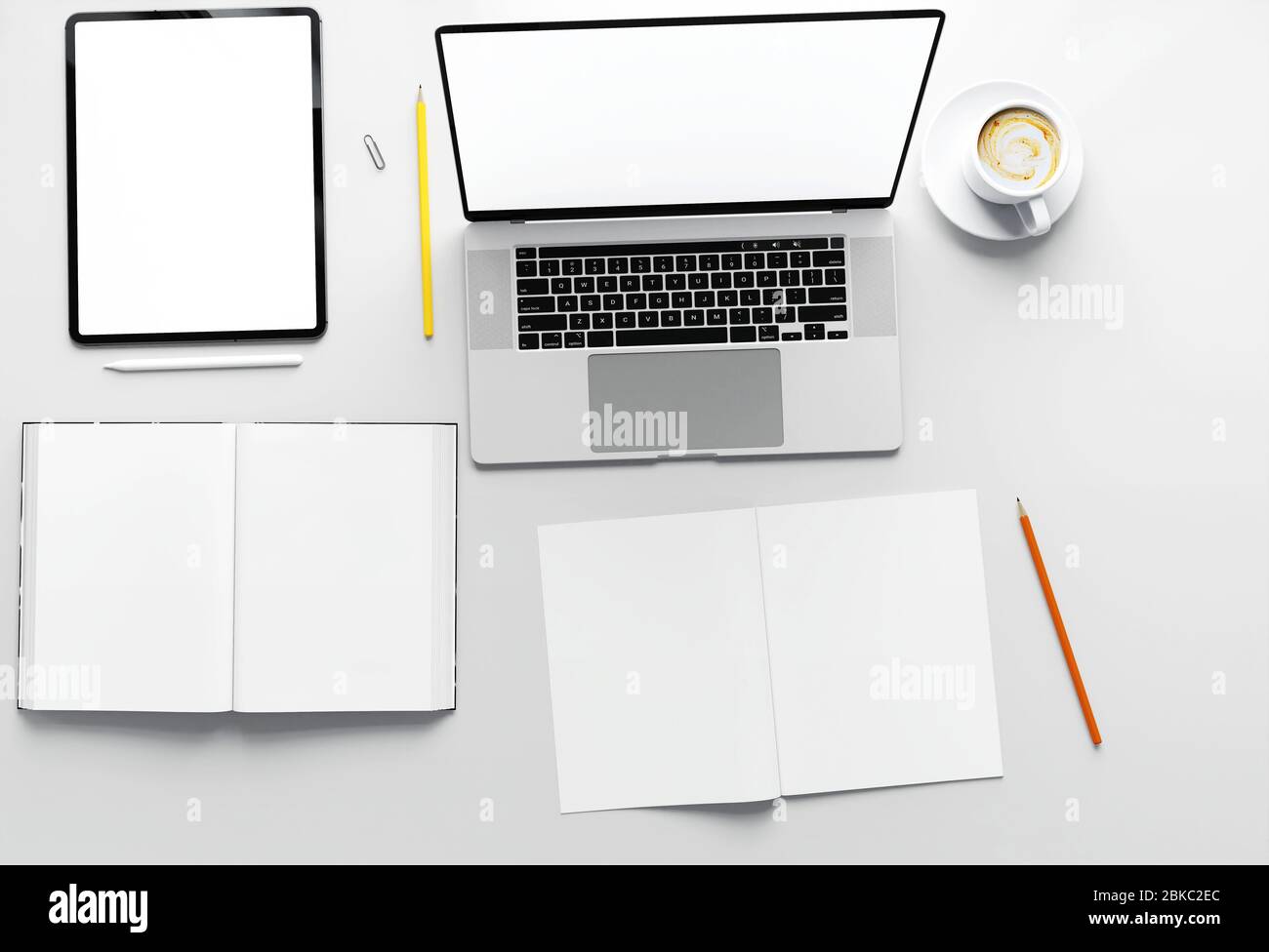 Piano superiore del tavolo in un parco di lavoro con tablet e libro o notebook in interni moderni per ufficio, design bianco minimalista, design di scena mockup, 3D Foto Stock