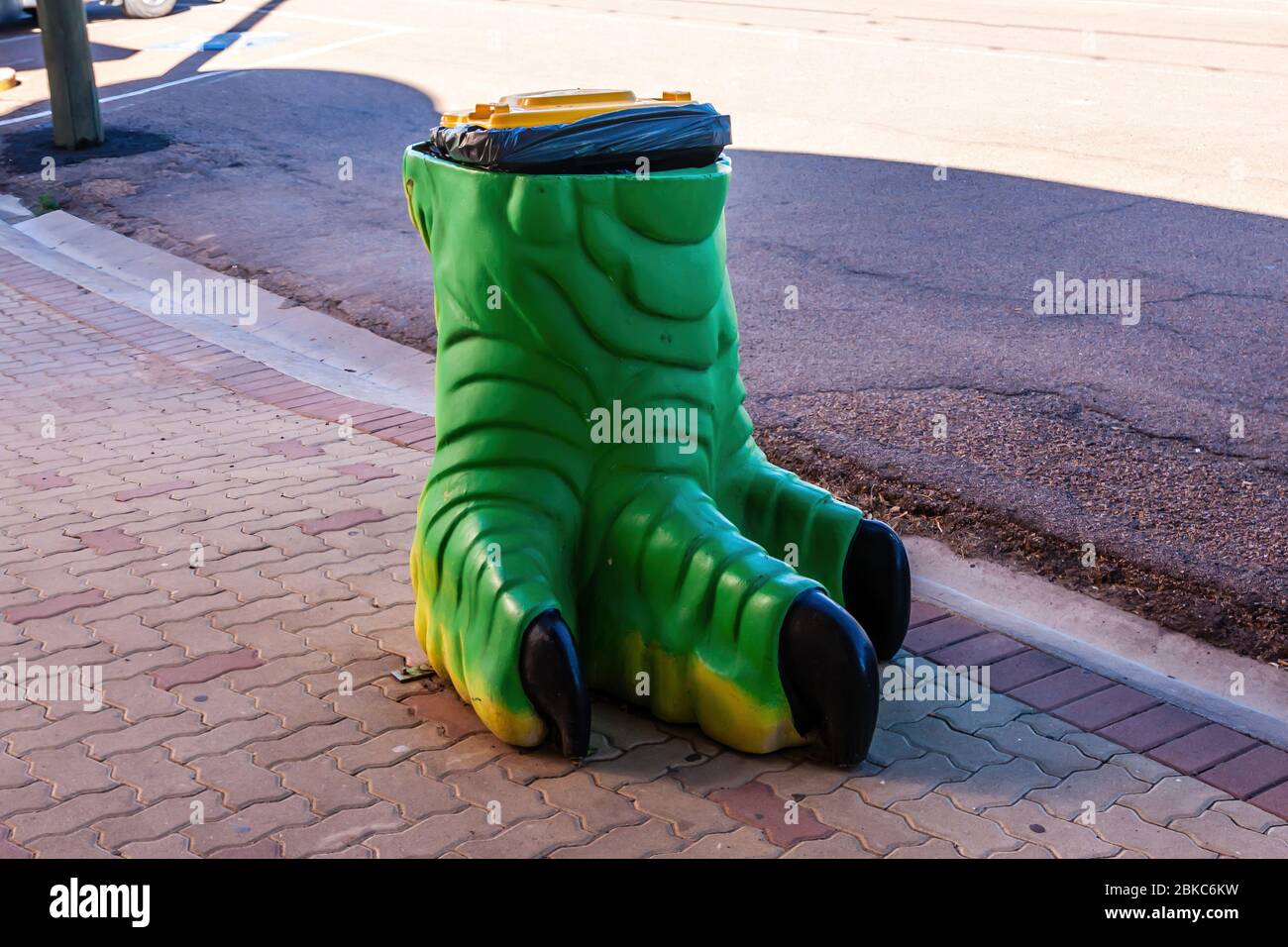 Un cestino spazzatura stradale del disegno del piede del dinosauro, Winton, Australia Foto Stock